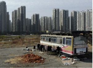 Clothes are seen hanging outside a bus which has been converted into a dwelling for Lu Changshan and his wife near newly-constructed residential buildings in Hefei, Anhui province in China on November 12, 2012 (Jianan Lu/Courtesy Reuters).